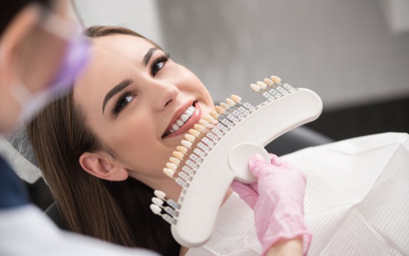 Physician enclosing dental crown to happy lady