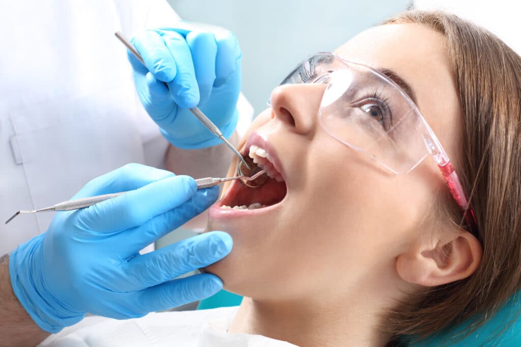 Dentist checking her patient's teeth for her Root canals treatment in Mississauga