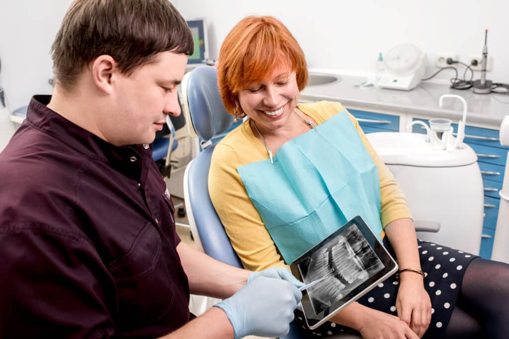 The dentist showing a teeth xray result to her patient for Dental Implants in Mississauga