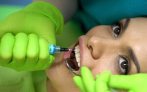 dentist putting blue gel tooth modeling paste cosmetic dentistry closeup