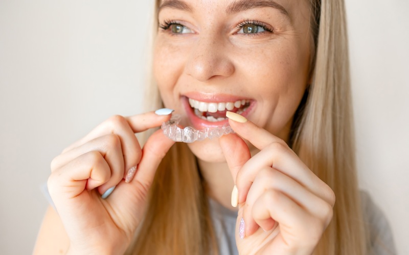 young woman holding invisible aligner dental health beautiful smile